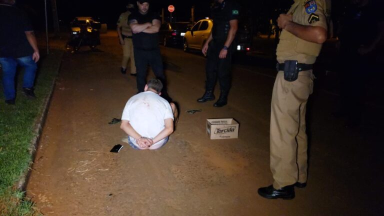 Homem passa na rua exibindo arma e apanha de populares