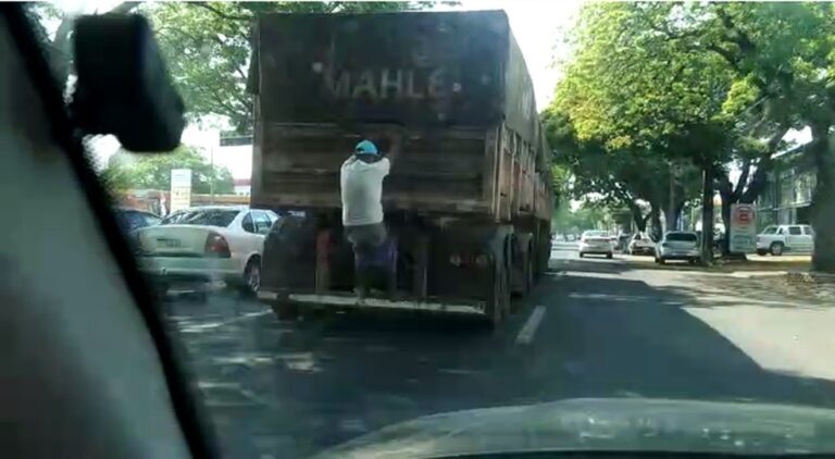 Homem se pendura em traseira de caminhão
