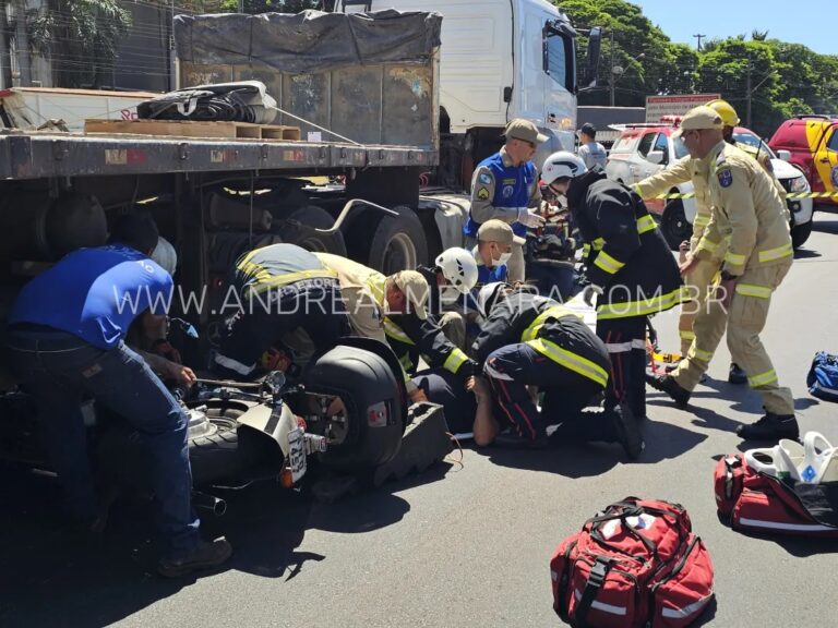 Motociclista fica preso embaixo de carreta
